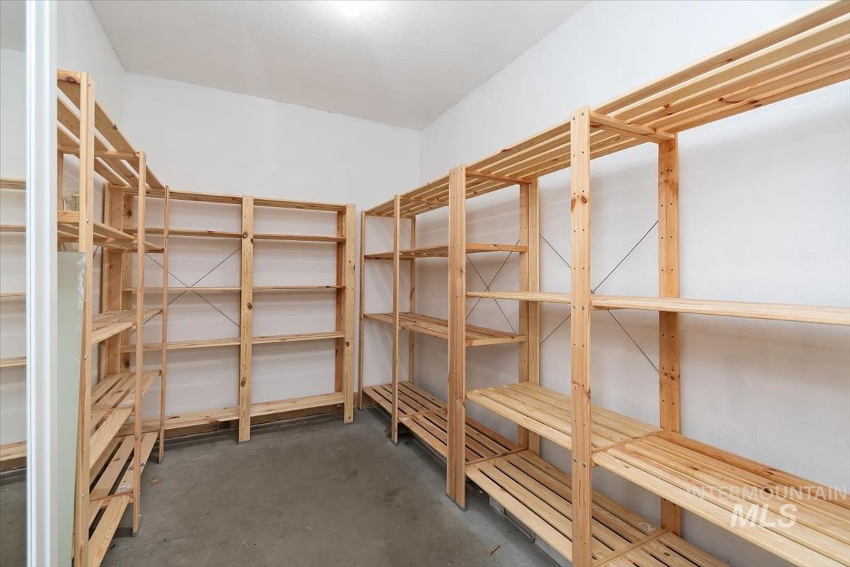 2217 North Middlefield Road Boise, ID 83704 - Photo 30 of 34 Storage room featuring extensive built-in wooden shelving, a white painted ceiling, light-colored walls, and concrete flooring