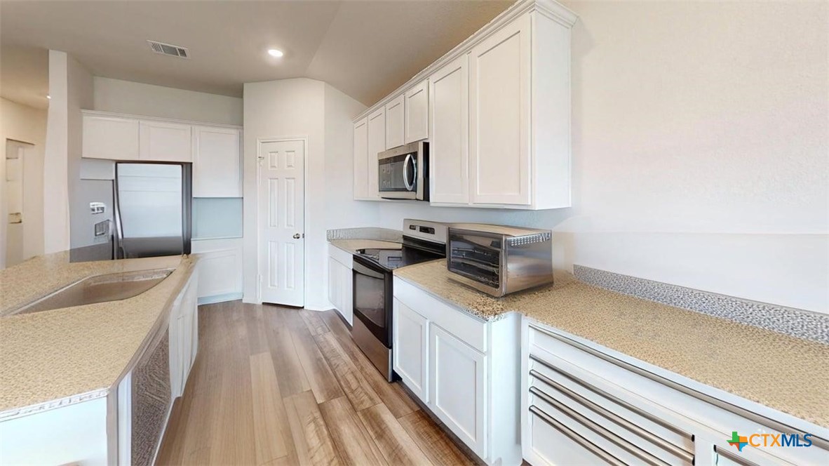 10016 Avendesora Road Killeen, TX 76542 - Photo 6 of 24 a kitchen with a sink and a stove top oven