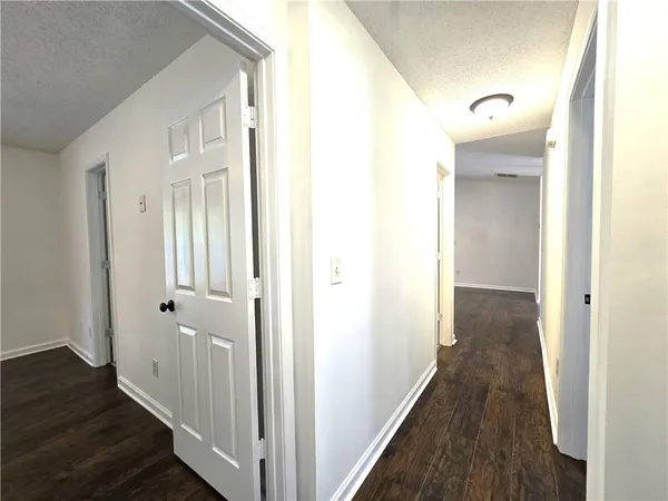 a view of a hallway with wooden floor