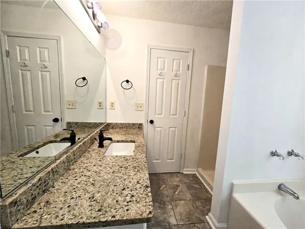 a spacious bathroom with a granite countertop tub sink and a shower
