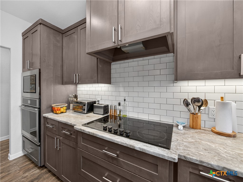 494 Flash Circle Luling, TX 78648 - Photo 12 of 44 a kitchen with stainless steel appliances granite countertop a sink stove and refrigerator