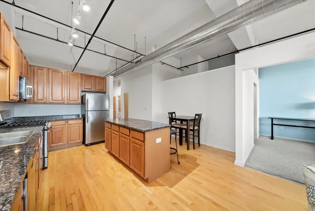 a kitchen with stainless steel appliances granite countertop a sink a stove counter space and cabinets