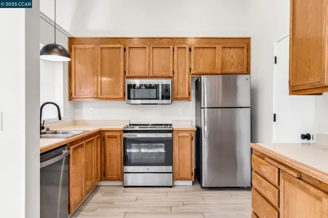 a kitchen with stainless steel appliances granite countertop a refrigerator sink and stove