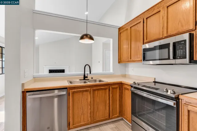 a kitchen with stainless steel appliances granite countertop a sink a stove and microwave