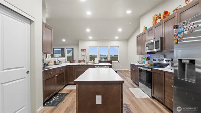 a large kitchen with stainless steel appliances granite countertop a sink a stove and cabinets