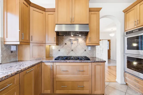 a kitchen with kitchen island granite countertop white cabinets and white appliances