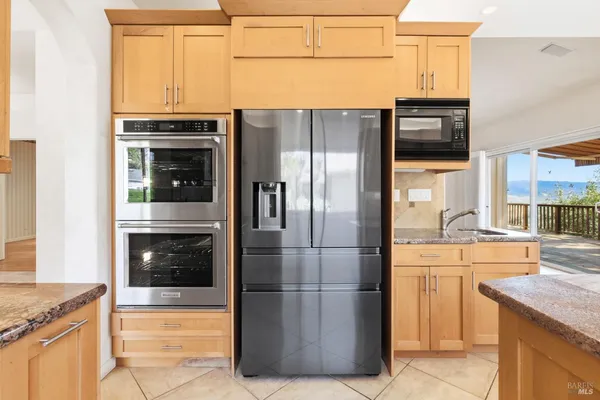 a kitchen with granite countertop a refrigerator and a stove top oven
