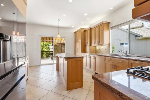 a kitchen with stainless steel appliances granite countertop sink stove and refrigerator