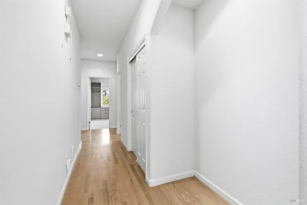 a view of a room with wooden floor and a hallway