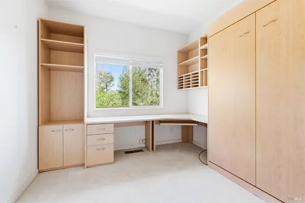 a kitchen with white cabinets and a window