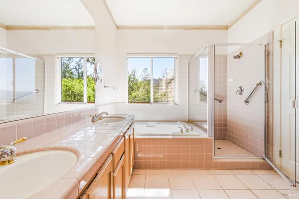 a spacious bathroom with a granite countertop tub shower sink and mirror