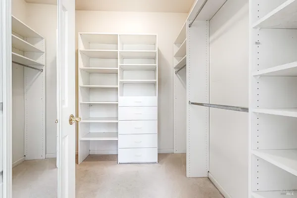 a view of walk in closet with empty racks