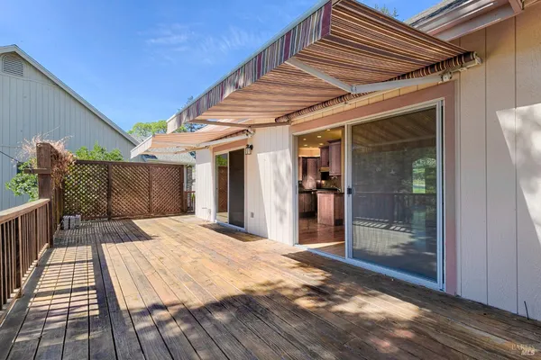 a view of a patio with table and chairs with wooden floor and fence