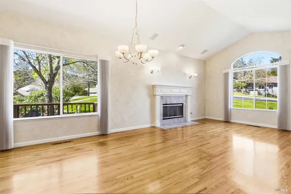 a view of an empty room with a window and kitchen view