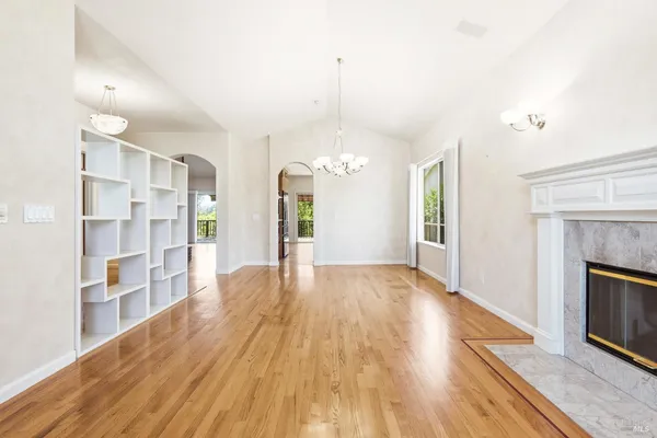 a view of empty room with wooden floor and fireplace