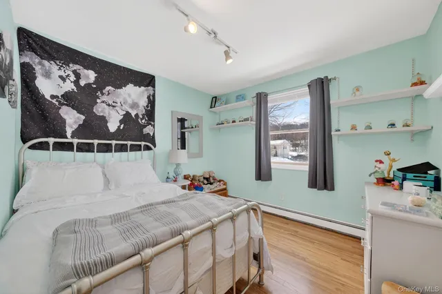 a bedroom with a bed and wooden floor