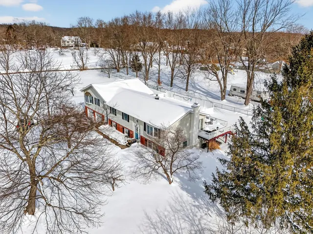 a view of a house with a yard and covered with snow