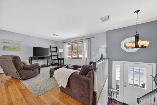 a living room with furniture a flat screen tv and a window