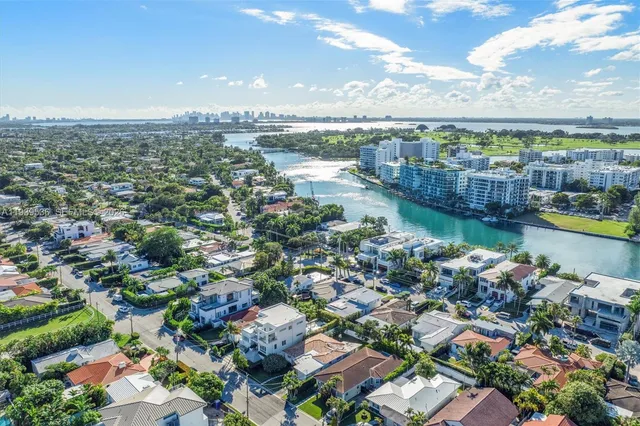 an aerial view of a city with lots of residential buildings ocean and mountain view in back