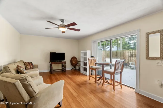 a living room with wooden floor and a large window