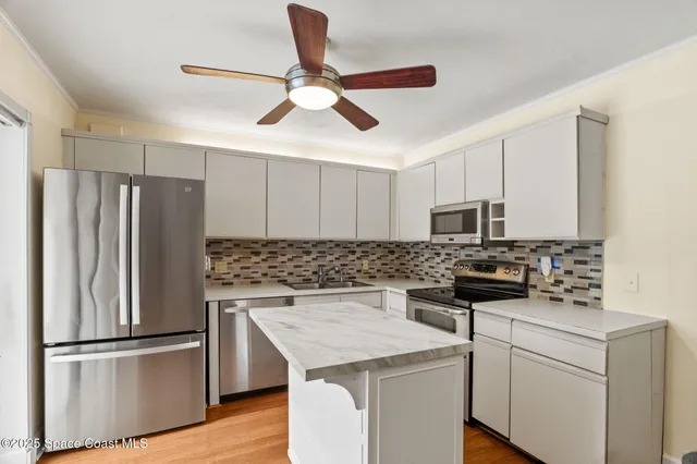 a kitchen with stainless steel appliances granite countertop a stove a sink and a refrigerator