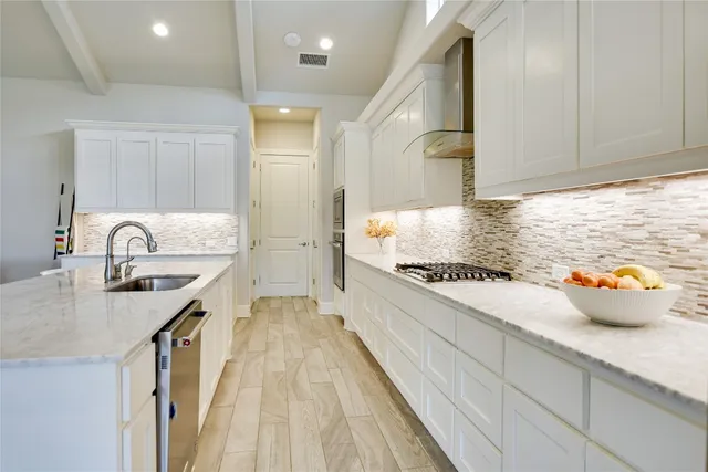 a kitchen with sink a stove and cabinets