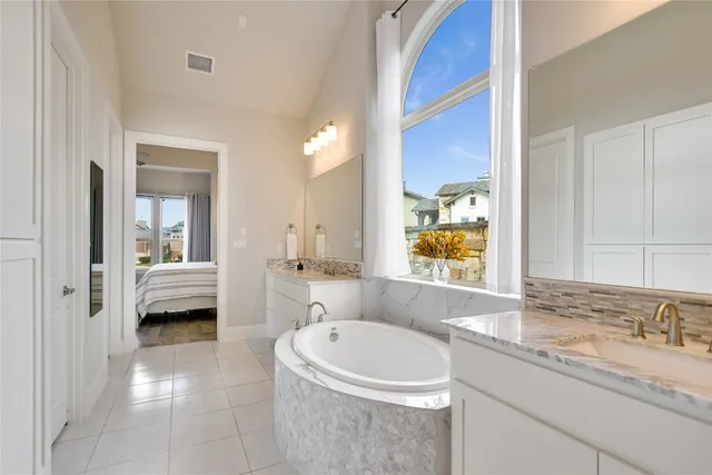 a bathroom with a granite countertop tub sink and mirror