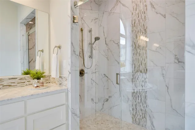 a bathroom with a sink vanity granite and shower