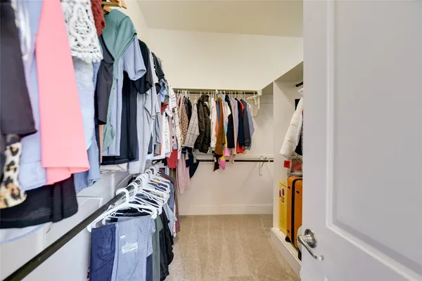 a view of walk in closet with clothes and shoes