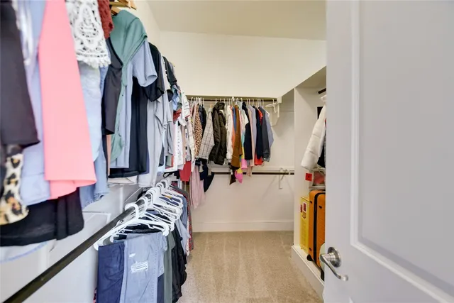 a view of walk in closet with clothes and shoes