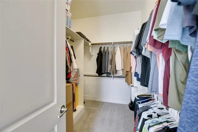 a view of walk in closet with clothes and shoes