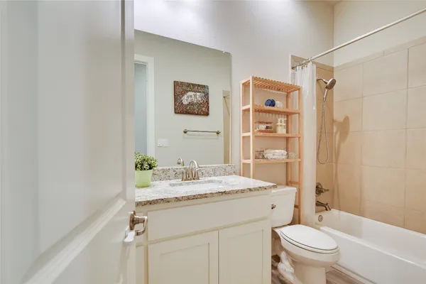 a bathroom with a granite countertop sink mirror vanity and toilet