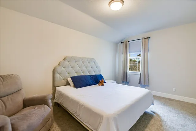 a bedroom with a bed couch and window