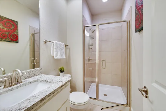 a bathroom with a granite countertop sink toilet and shower