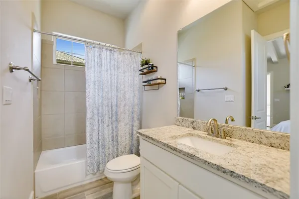 a bathroom with a granite countertop sink toilet and shower