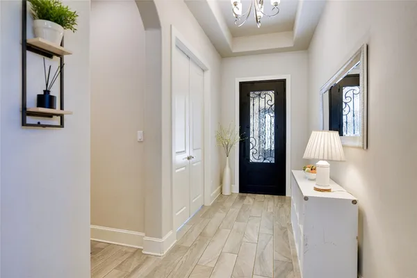 a hallway with front door wooden floor and windows