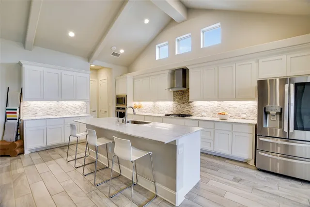 a kitchen with cabinets and chairs