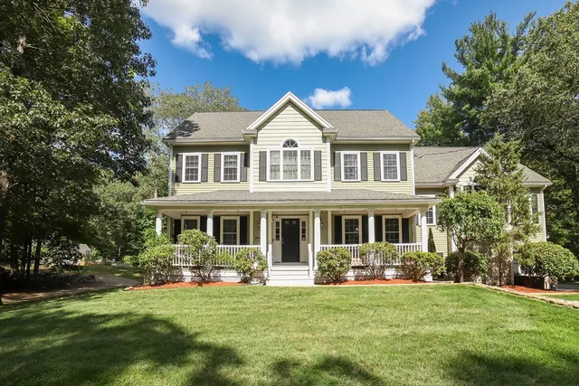 a front view of a house with a garden and trees