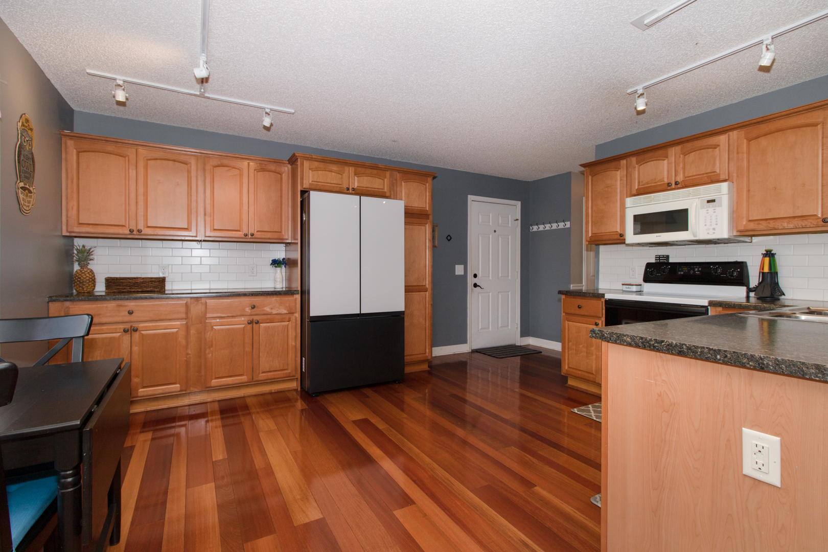 8 Holder Way Bloomington, IL 61704 - Photo 12 of 44 a kitchen with stainless steel appliances granite countertop a refrigerator a stove top oven a sink dishwasher and white cabinets with wooden floor