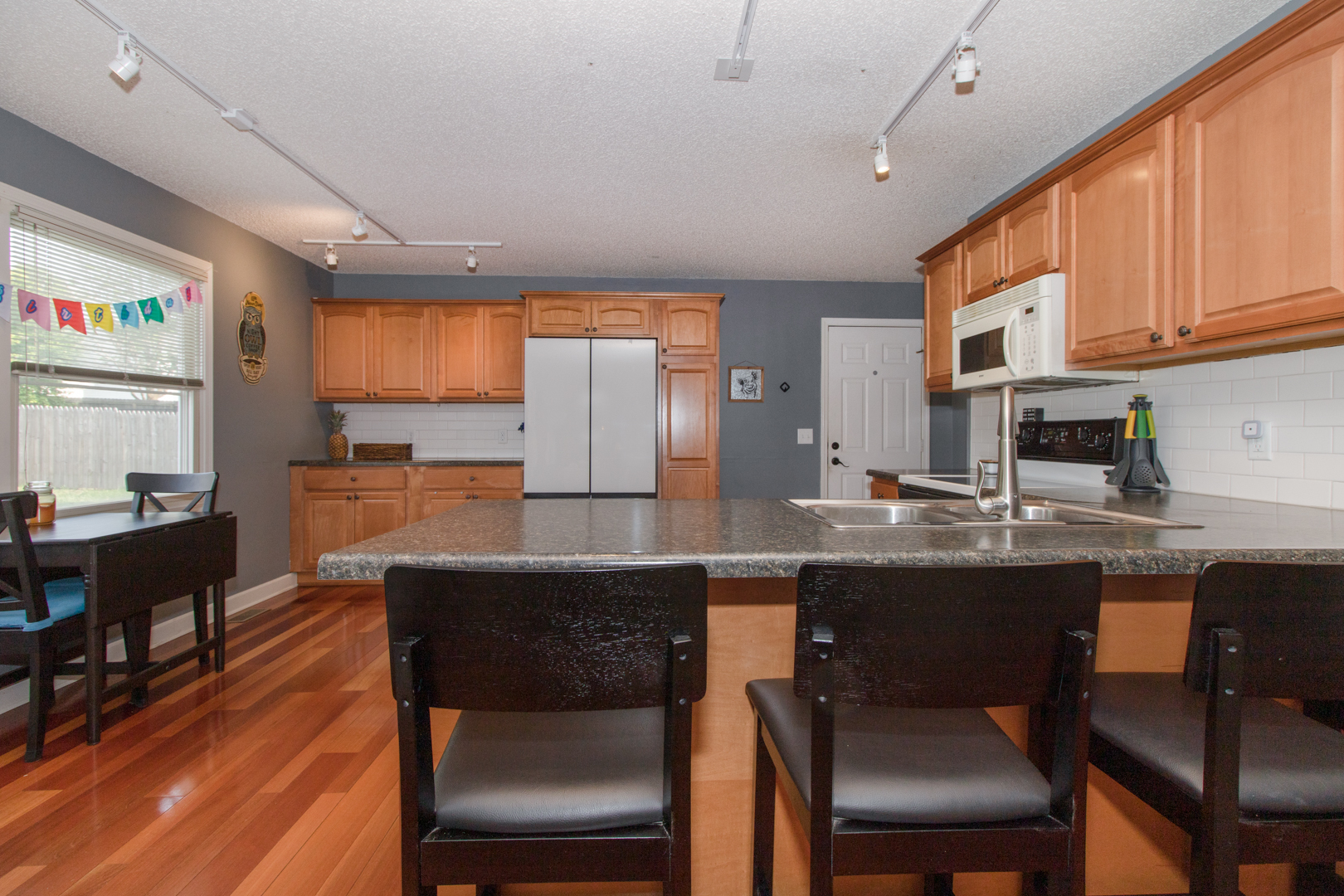 8 Holder Way Bloomington, IL 61704 - Photo 17 of 44 a kitchen with stainless steel appliances granite countertop a table chairs sink and cabinets