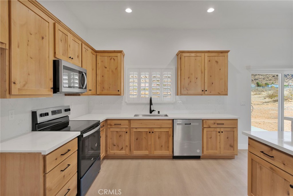 15575 Desert Star Road Apple Valley, CA 92307 - Photo 8 of 24 a kitchen with stainless steel appliances granite countertop a sink stove and cabinets