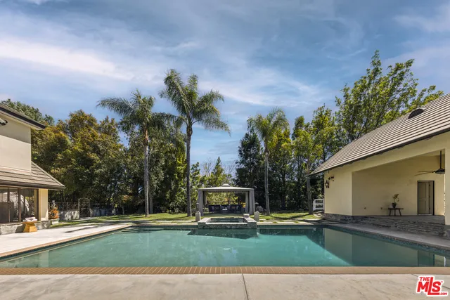 a view of a house with swimming pool and sitting area