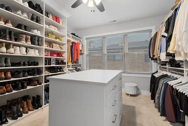 a view of walk in closet with clothes and shoes