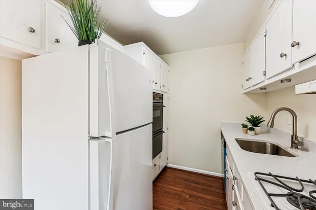 a kitchen with white cabinets and appliances