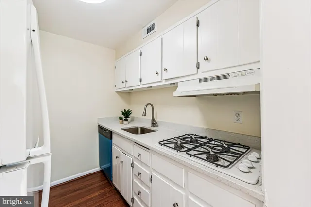 a kitchen with stainless steel appliances a sink a stove and cabinets