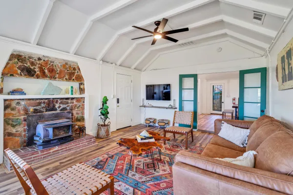 a bedroom with a bed and dresser with wooden floor