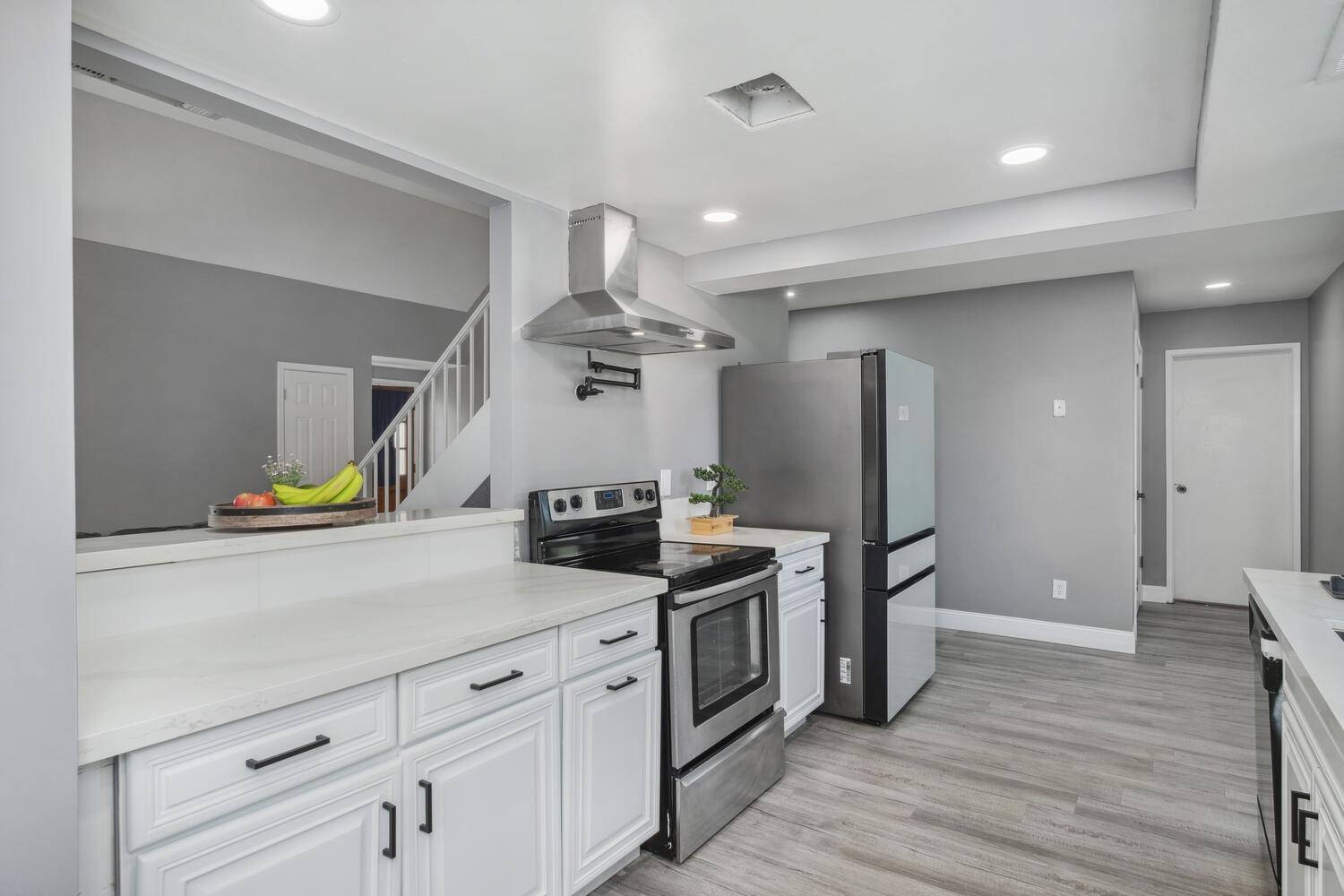 133 Armstrong Avenue Clovis, CA 93611 - Photo 12 of 25 a kitchen with stainless steel appliances wooden floor and a refrigerator