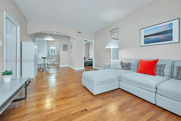 a living room with furniture and a wooden floor