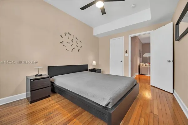 a spacious bedroom with a bed and wooden floor