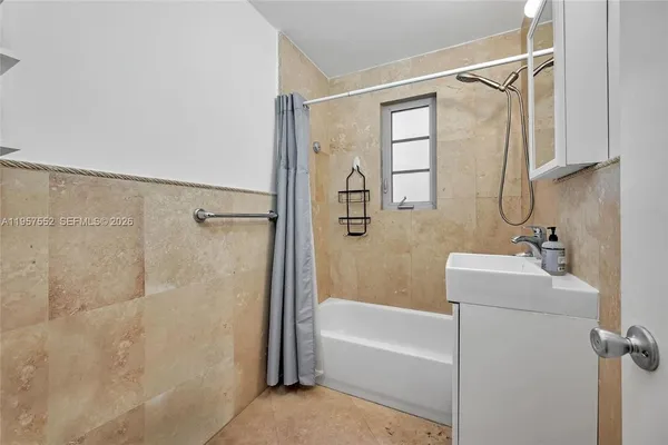 a bathroom with a tub a sink and a shower